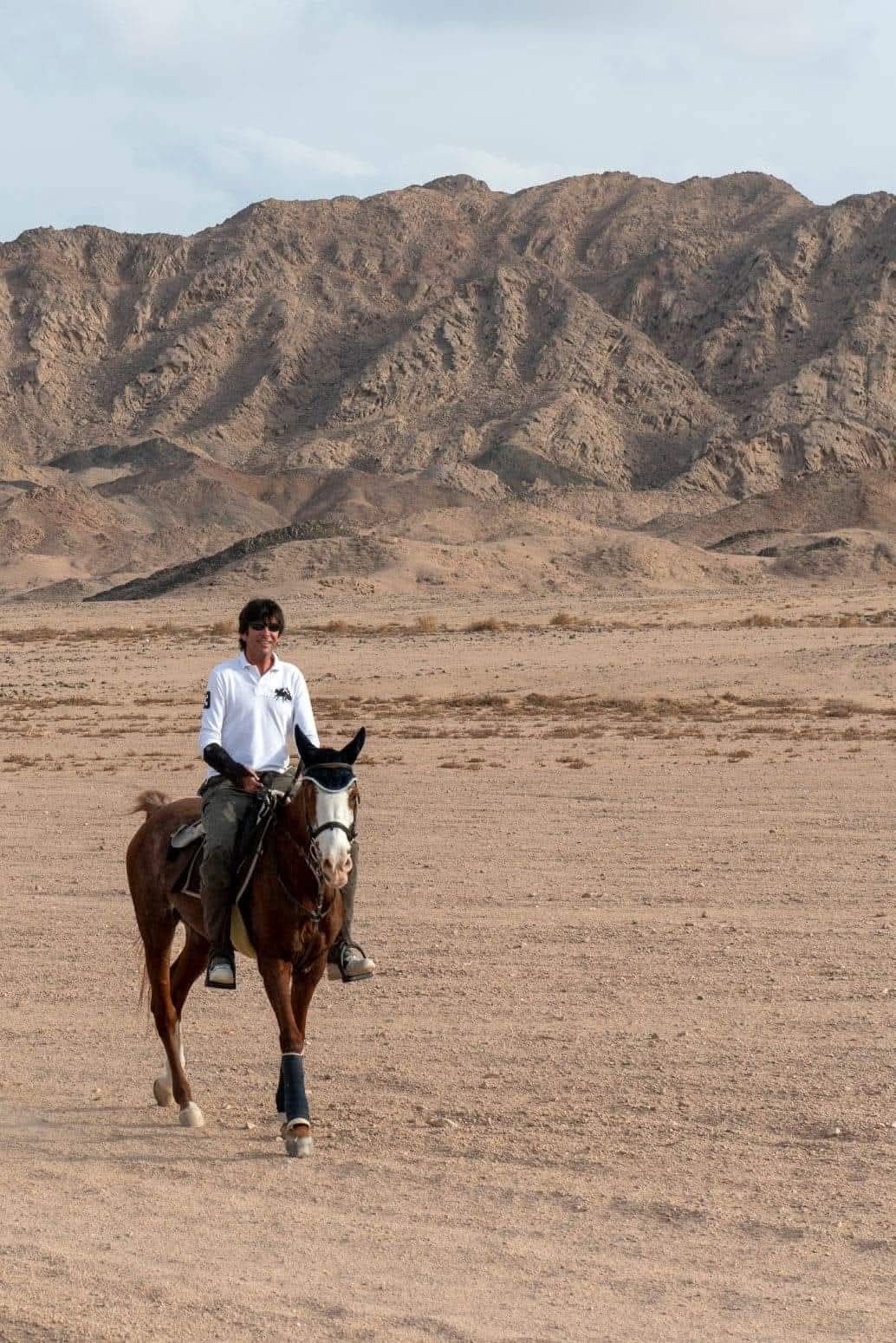 Alain à cheval dans le désert d'Égypte, montagnes en arrière-plan
