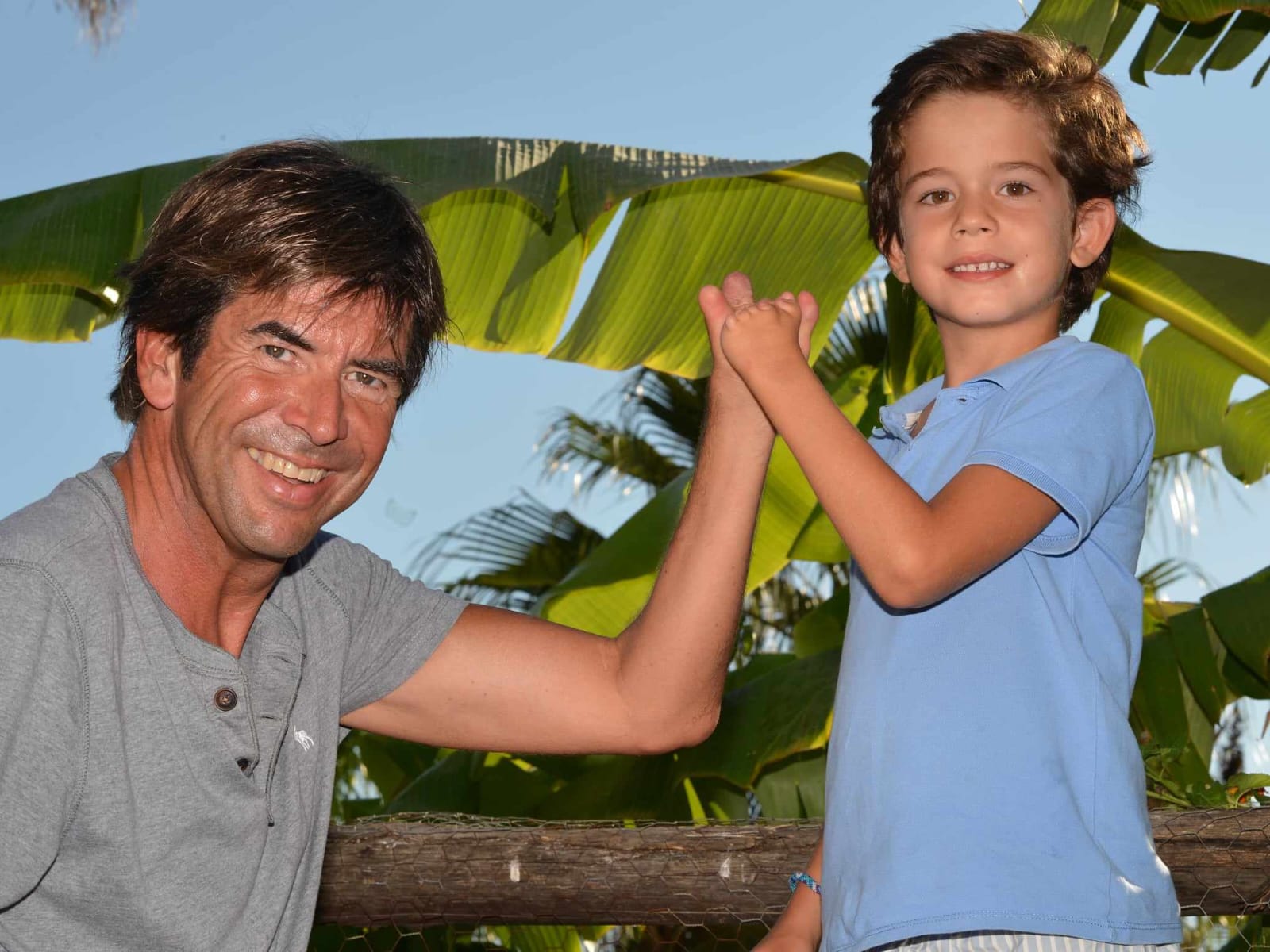 Alain avec son petit-fils, mains jointes, soleil tropical